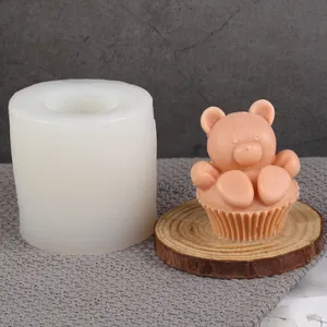 Detailed view of DIY silicone bear candle mold with finished peach-colored bear wax model