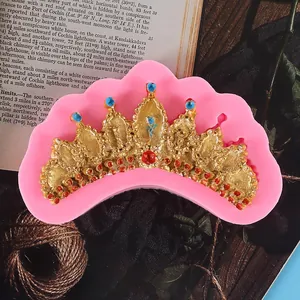 Close-up detail of a pink crown silicone mold with golden fondant crown decoration