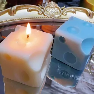 Nahaufnahme von käseförmigen Kerzen in Weiß und Blau auf einem Spiegel