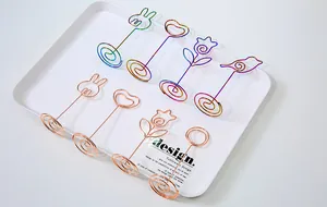 Macro view of rainbow and rose gold metal memo clips in various cute shapes