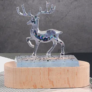 Detail of a translucent resin deer ornament with multicolored glitter on a wooden base
