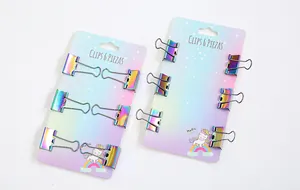 Detailansicht von zwei Packungen schillernder Regenbogen-Binderclips auf dekorativen Karten