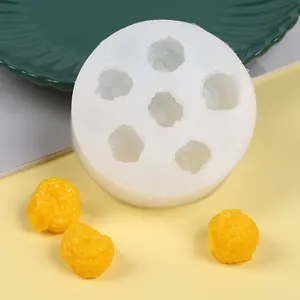 Vista detallada de un molde de silicona para palomitas 3D DIY con accesorios amarillos.