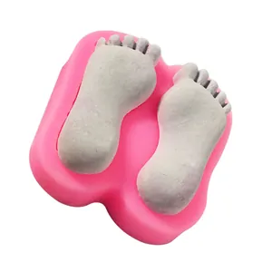 Detailed close-up of a pink baby feet silicone mold showing the finished fondant product