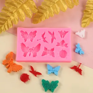 Vue détaillée d'un moule en silicone papillon avec des décors en fondant colorés.