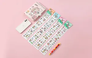 Macro view of five cute cartoon PVC stickers for DIY planners on a pink background.