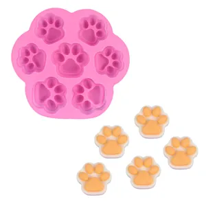 Detalle del molde de silicona rosa con forma de pata y pequeños productos terminados