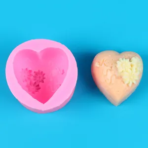 Detailed view of pink heart silicone mold next to a finished cream heart-shaped cake decoration