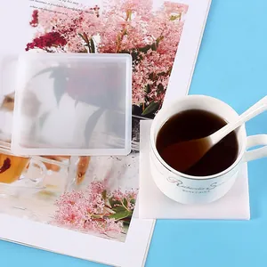 Square silicone coaster mold with finished resin coaster and white coffee cup detail