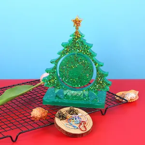 Detail view of a green glittery resin Christmas tree desktop ornament for DIY crafts.