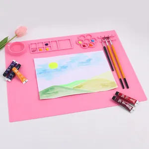 Dettaglio del tappetino artistico in silicone rosa con tavolozza e porta pennelli