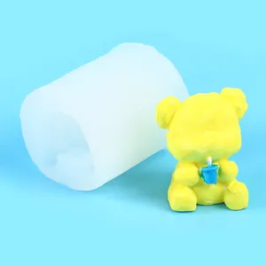 Detail view of a 3D bear silicone mold and a finished handmade yellow candle craft