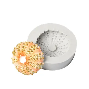 Close-up of sea urchin silicone mold and a finished coral-colored fondant piece.