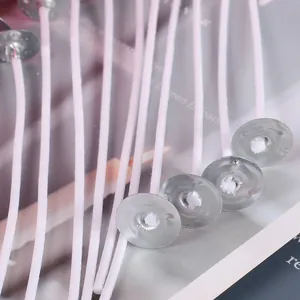 Detailed view of cotton candle wicks with silver metal sustainer tabs for DIY crafts.