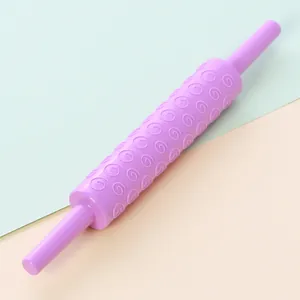 Close-up of a purple plastic fondant rolling pin featuring a spiral embossed pattern