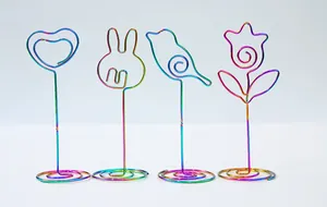 Close-up of iridescent metal memo clips in heart, bunny, bird, and flower shapes
