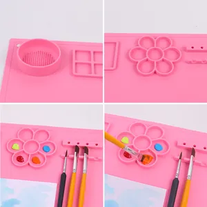 Dettaglio del tappetino in silicone rosa per pittura con tavolozza e area di pulizia