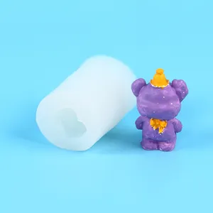 Close-up detail view of the 3D cartoon bear silicone mold next to a finished purple candle
