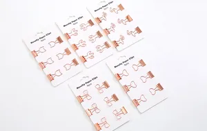 Detailansicht neuartiger Büroklammern in Roségold mit verschiedenen kreativen Formen