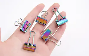 Detailaufnahme einer Hand mit fünf kleinen bunten, schillernden Metall-Klammern