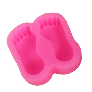 Macro view of pink silicone mold with cute baby footprint cavities for cake DIY