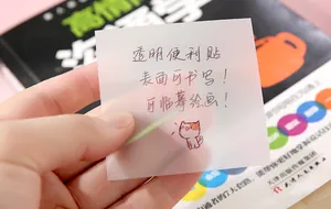 Hand holding a transparent sticky note showing its writable surface and clarity
