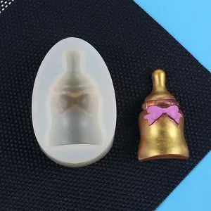 Vue détaillée d'un moule en silicone en forme de biberon avec échantillon en résine dorée.