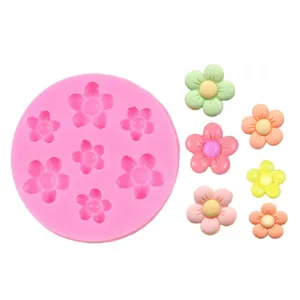 Detail of pink silicone mold with flower cavities and colorful resin sunflower samples
