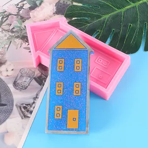 Macro detail of house-shaped silicone mold shown with a finished blue resin craft house