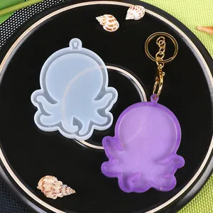 Set de molde de silicona de pulpo con llavero de resina violeta en un plato negro