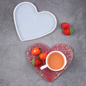 Vista dettagliata dello stampo in silicone a cuore e di un sottobicchiere in resina glitterata