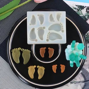 Vue macro du moule en silicone empreinte de bébé avec breloques de pied en résine sur assiette