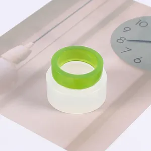 Vue détaillée d'un moule à bague en silicone et d'une bague en résine verte finie