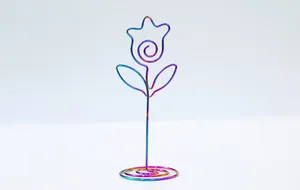 Detail view of a creative rainbow metallic flower-shaped note holder and memo clip.