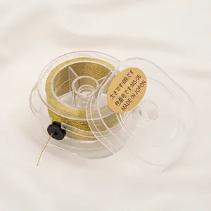 Close-up of 6-ply gold metallic embroidery thread on a clear plastic spool