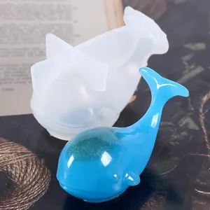 Detailansicht einer 3D-Walfisch-Silikonform neben einem blauen fertigen Harz-Wal-Handwerk