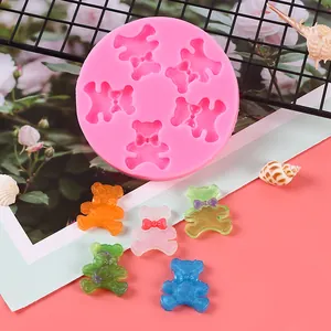Macro view of pink mini teddy bear silicone mold with colorful finished resin bears