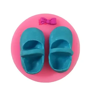 Close-up of blue baby shoes and purple bow shapes created from handmade silicone mold