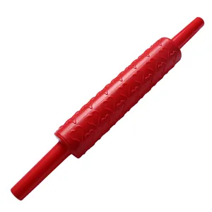 Detailed view of a red plastic rolling pin with an embossed heart pattern for baking