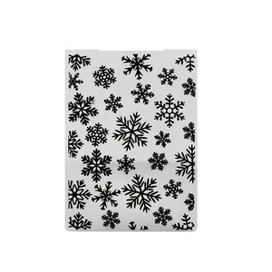 Detail showing various snowflake patterns on a semi-transparent plastic drawing stencil