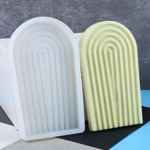 Détail d'un moule en silicone en forme d'arche avec un plateau de bougie vert texturé.