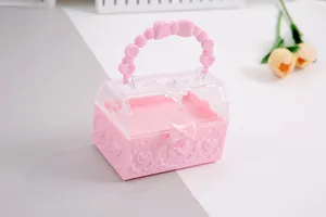 Detailansicht einer rosa Schatztruhe aus Kunststoff mit Herz- und Schleifenmustern