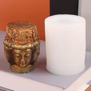 Gros plan d'un moule en silicone tête de Bouddha avec une bougie décorative dorée.