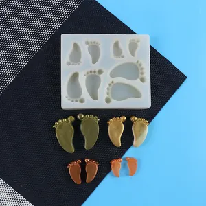 Détail du moule en silicone pieds de bébé avec des échantillons de résine dorée