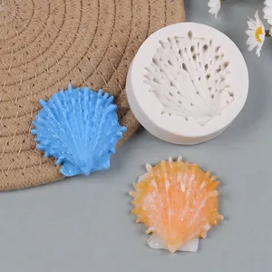 White silicone mold with detailed seashell texture and two resin shell samples