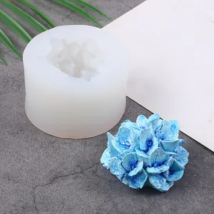 Detailed view of a blue floral resin piece and its cylindrical silicone mold tool