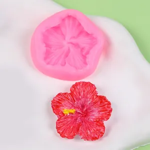 Detailed macro view showing pink floral silicone mold alongside a finished red resin flower
