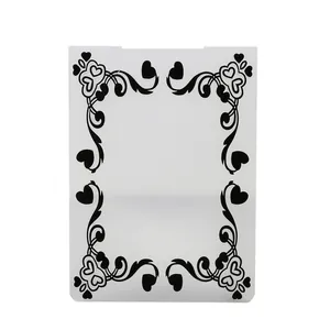 Macro detail of embossing folder featuring black heart and scrollwork pattern designs