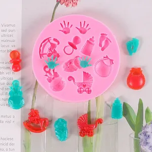 Macro detail of baby-themed silicone mold with hand, bottle, and stroller shapes