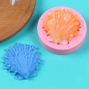 Detailed view of a pink silicone mold and a finished blue scallop shell fondant piece.